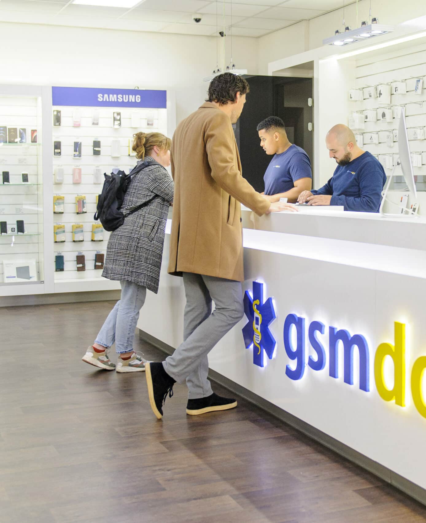 Klanten aan de balie van GSM Dokter in Rotterdam
